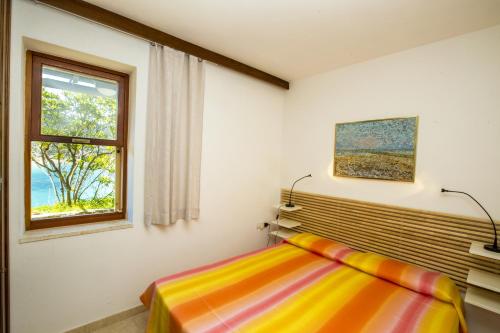 费拉约港Un Nido sul Mare - Goelba的一间卧室设有一张床和一个窗口