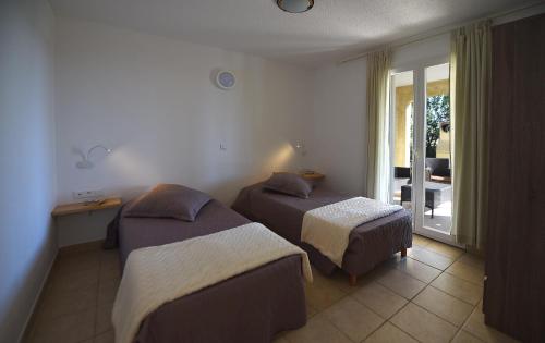 韦基奥圣露西港口Résidence Chiar' Di Luna的酒店客房设有两张床和一个阳台。