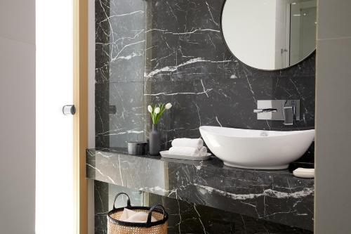 塞萨洛尼基卢森堡酒店的浴室设有白色水槽和镜子