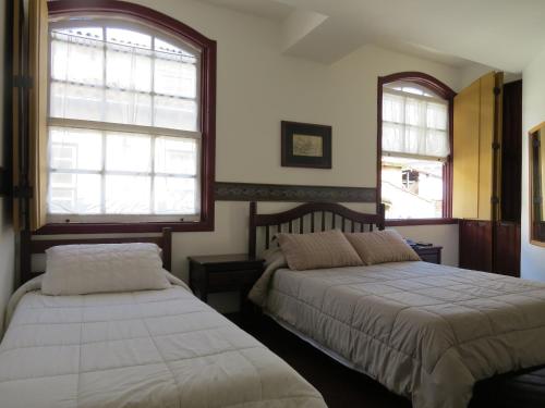 欧鲁普雷图Hotel Colonial的一间卧室设有两张床和两个窗户。