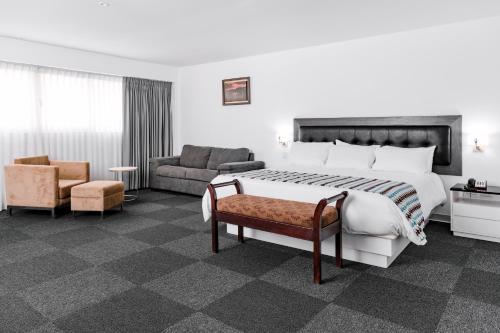 通贝斯太阳海岸温德姆通贝斯酒店的酒店客房设有一张大床和一张沙发。