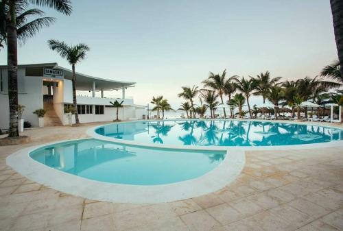 拉古纳the million view room habitacion en resort solo adultos的一座棕榈树大型游泳池和一座建筑