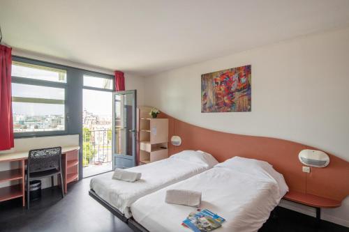 巴黎CIS巴黎莫里斯拉威尔酒店的一间卧室配有一张床、一张书桌和一个窗户。