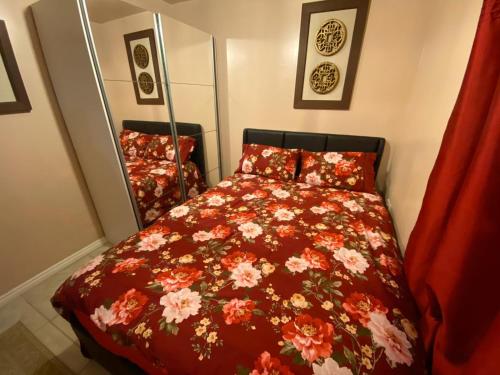 牛津Guest House B&B的一间卧室配有一张带红色花卉棉被的床