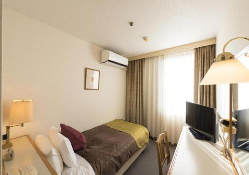 鱼津skyhotel uozu / Vacation STAY 59574的配有一张床和一张书桌的酒店客房