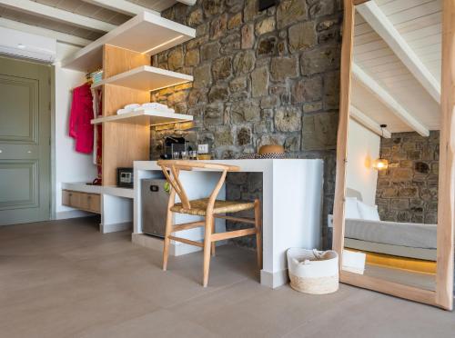 阿达玛斯Hotel Milos Sea Resort的厨房配有桌子和石墙