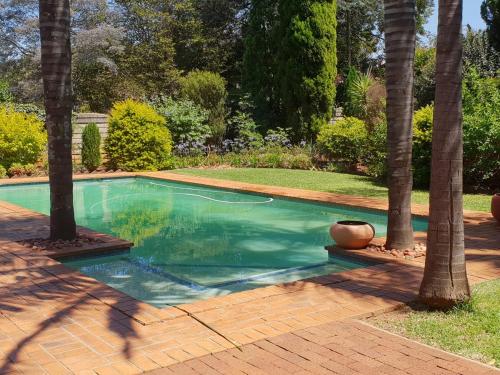 逊邱伦Accommodation@Bourne的庭院内棕榈树游泳池