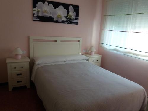 莱斯卡瑟斯-达尔卡纳Apartamento Lepanto Playa的卧室配有白色的床和2个床头柜
