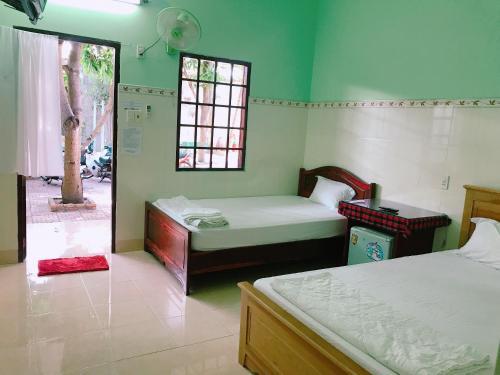 美奈Anh Linh Guest House的客房设有两张床和窗户。