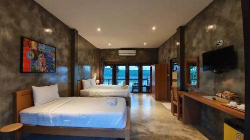 清刊Chiang Klong Riverside Resort的酒店客房设有两张床和电视。