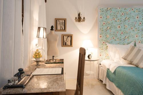 布希奥斯巴尔萨泽别墅酒店的一间卧室配有一张床和一张桌子,桌子上配有四柱床。