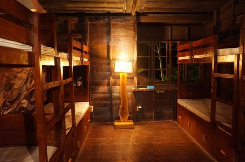 邦劳Peaceland Hostel的客房设有两张双层床和一盏灯。