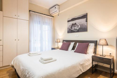 雅典Ioannis Cozy Apartment 500 meters from Acropolis museum的卧室设有一张白色大床和一扇窗户。