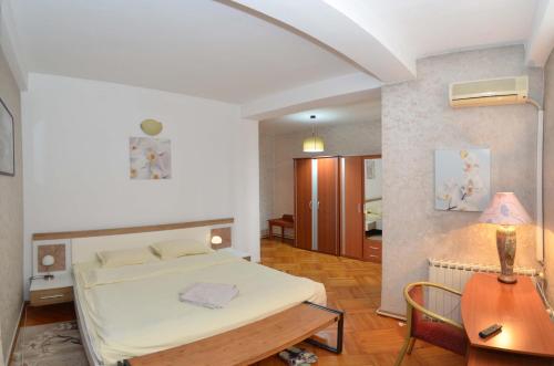 布加勒斯特维拉A&B酒店的卧室配有1张床、1张桌子和1把椅子