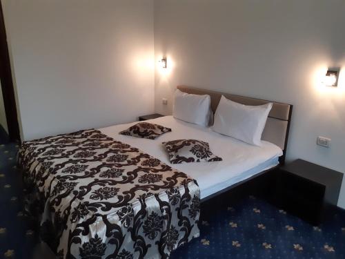 BîrladHotel Ro&Mario Barlad的小房间的一个床位,上面有两个枕头