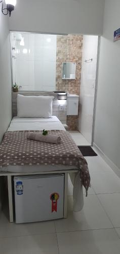 大瓦尔泽亚Pertinho do Aeroporto Hospedagem Particular的小房间设有床和小浴室