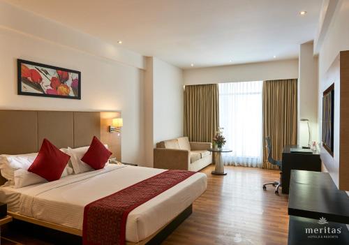 罗纳瓦拉Meritas Picaddle Resort Lonavala的酒店客房带一张大床和一把椅子