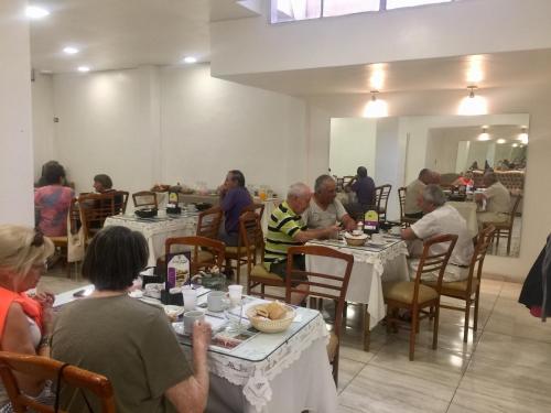 圣胡安Hotel Plaza San Juan的一群坐在餐厅桌子上的人