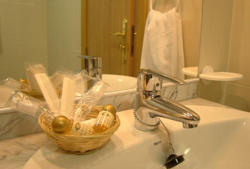 马德里恩卡萨公寓酒店的浴室水槽和水槽上的篮子