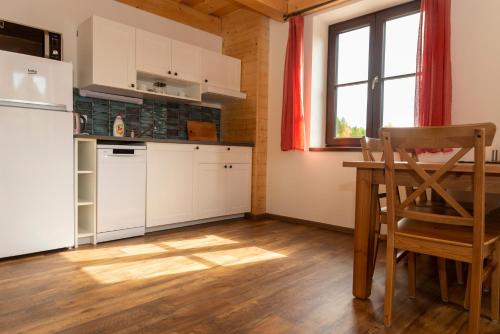 克维尔达Apartmány Verunka的厨房配有白色橱柜、桌子和窗户。