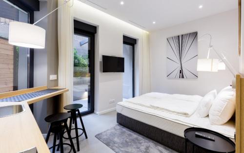 贝尔格莱德Teanna Lux Apartments的卧室配有一张挂在墙上的带时钟的床