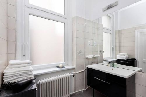 布达佩斯Contemporary City Apartment Váci Utca的一间带水槽、窗户和镜子的浴室