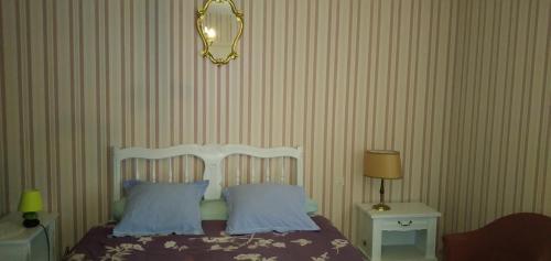 Campagnechambre d'hôte的一间卧室配有一张带两个枕头和镜子的床