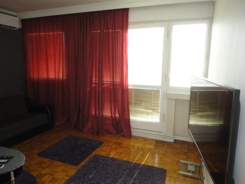 贝尔格莱德Autokomanda的客厅配有红色窗帘和大窗户