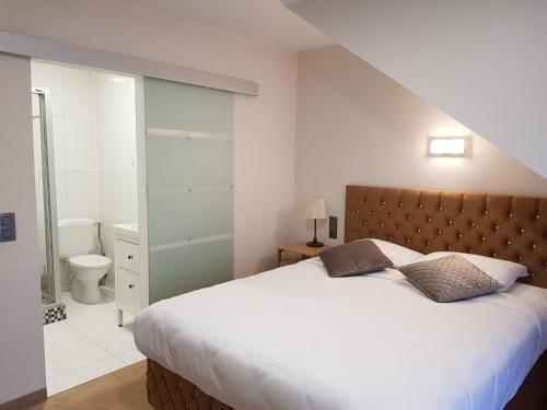布鲁塞尔魅力贝尔酒店的一间带大床的卧室和一间浴室