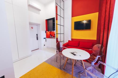 利沃夫Cities Gallery Apart-hotel的客厅配有红色的沙发和桌子