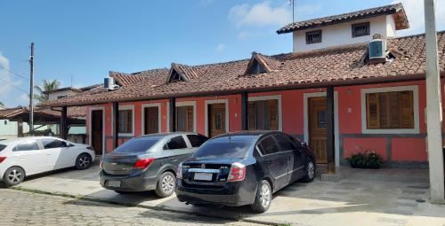伊利亚贝拉Patricio's Chalés Ilhabela的两辆汽车停在房子前面的停车场
