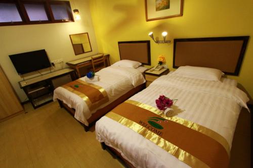 龙运SIX VILLA INN的酒店客房设有两张床和一台平面电视。