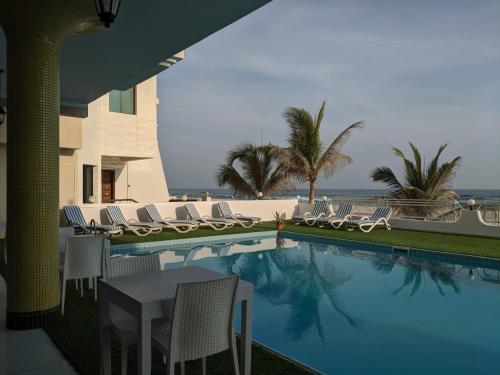 塞拉莱Salalah Beach Villas的一个带桌椅的海洋游泳池