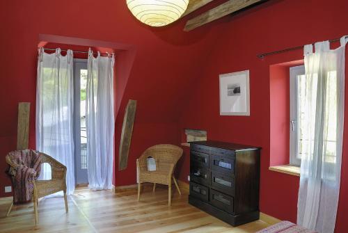 Salles-la-SourceGite de la Cascade的红色的房间,设有梳妆台和两个窗户