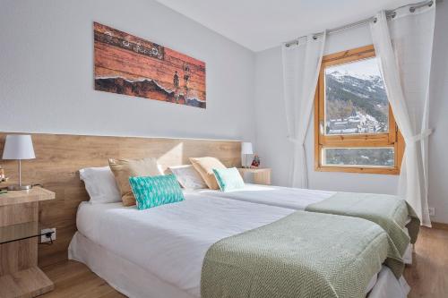 巴奎伊拉-贝莱特Acogedor Apartamento Baqueira 1500的一间卧室设有两张床和窗户。