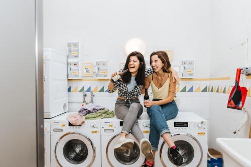 维也纳鲁滕斯坦奈维也纳旅馆 的两名妇女坐在洗衣房的洗衣机上