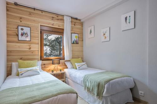 上阿兰Apartamento Renovado Baqueira 1500的木墙客房的两张床