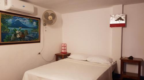 拉斯彭尼塔斯Tapihouse的卧室配有白色的床和墙上的绘画作品