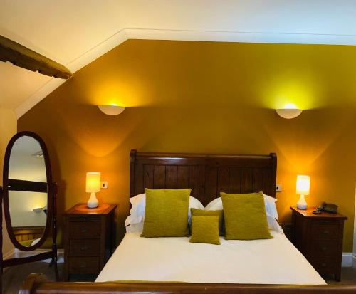 克里克豪厄尔Old Rectory Country Hotel的一间卧室配有一张大床、两盏灯和一面镜子