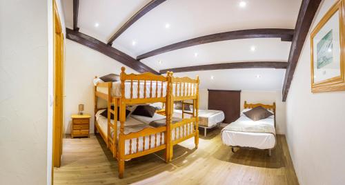 帕斯底拉卡萨莱斯诺斯酒店的一间卧室设有两张双层床和横梁天花板。
