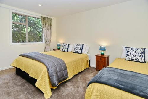 基督城Clyde 106 - Christchurch Holiday Homes的一间卧室设有两张床和窗户。