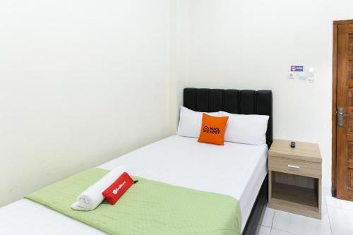 梭罗RedDoorz Syariah near Purwosari Train Station的一间卧室配有一张带两个枕头的床