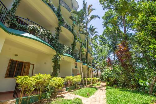 提喀迪Chrissie's Hotel的一座种有植物和树木的建筑的庭院