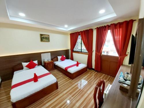 金边首都一号旅馆的酒店客房,设有两张床和红色窗帘