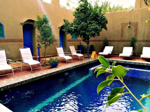 扎古拉小古堡酒店的一个带白色椅子和一组设施的游泳池