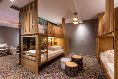 圣莫里斯堡Hotel Base Camp Lodge - Bourg Saint Maurice的一间设有两张双层床和两张凳子的房间