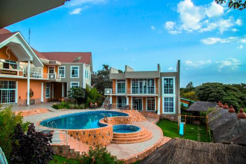 阿鲁沙Masailand Safari Lodge的庭院中带游泳池的房子