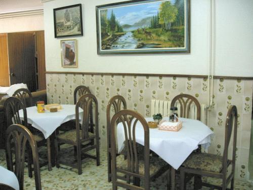 阿尔切纳帕拉酒店的一间用餐室,配有两张桌子和椅子,还有一幅画