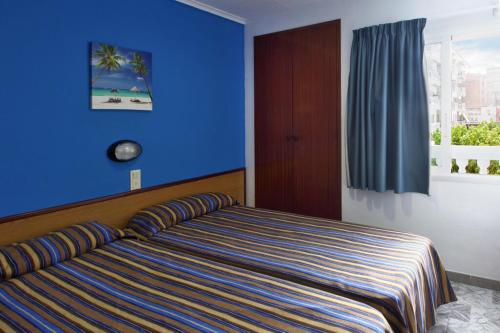 布拉内斯Europa Family Apartments的一间卧室配有一张蓝色墙壁的床