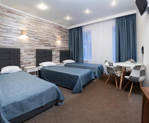 圣彼得堡Guest House Ligovsky的酒店客房设有两张床和一张桌子。